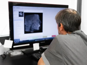 Il Dr. Ivan Dus illustra a un paziente le immagini diagnostiche su monitor per la diagnosi differenziale